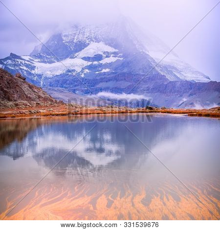 Colorful Pink Sunrise And Reflection Of Matterhorn Mountain At Riffelsee Lake, Zermatt Switzerland