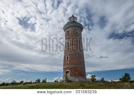 Lighthouse And House In The Baltic Sea. Shore, Evening Light, Sunset, Clouds And Architecture Concep