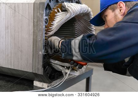 Perm, Russia - October 11, 2019: Worker Repairing A Stator Winding Of An Electric Motor In A Worksho