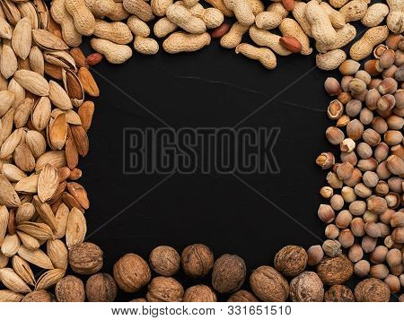 Natural Organic Nuts, Almonds, Peanuts, Walnuts And Hazelnuts On A Black Background. Top View. The C