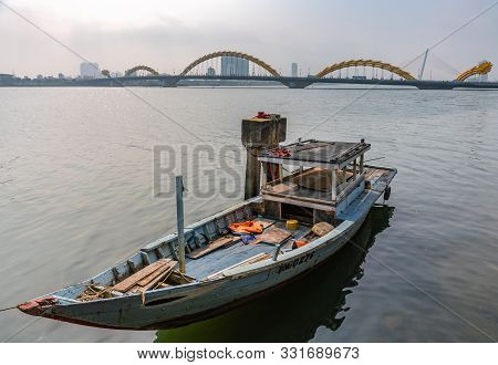 Da Nang, Vietnam - March 10, 2019: Sloop On Wide Han River And Cau Rong Or Dragon Bridge On Horizon 