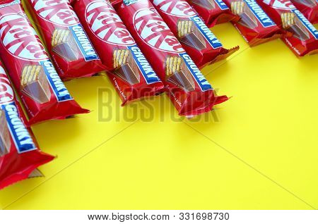 Kit Kat Chocolate Bars In Red Wrapping Lies On Yellow Background. Kit Kat Created By Rowntrees Of Yo