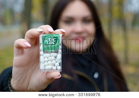 Kharkov, Ukraine - October 26, 2019: Young Woman Shows New Tic Tac Hard Mints Package In Autumn Park