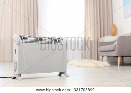 Modern Electric Heater On Floor At Home. Space For Text
