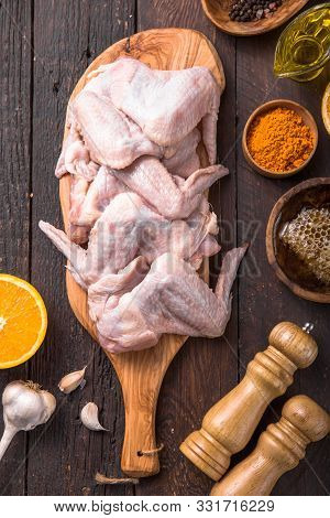 Raw Chicken Wings With Ingredients For Cooking: Hohey, Orange Fruit, Garlic, Olive Oil, Kari  On A W