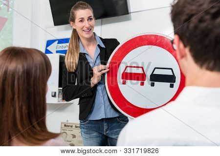 Driving instructor explaining meaning of street sign to class of students