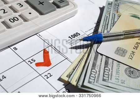 1065 Return Of Partnership Income Blank With Dollar Bills, Calculator And Pen On Calendar Page With 