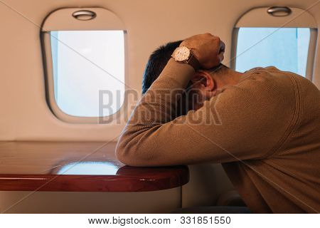 Scared Man With Airsickness Covering Face In Private Jet