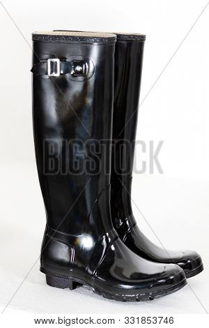 Stylish woman in black dress wearing overknee boots