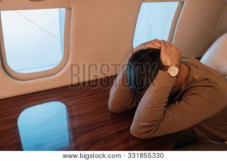 Frightened Man With Airsickness Covering Face In Private Jet