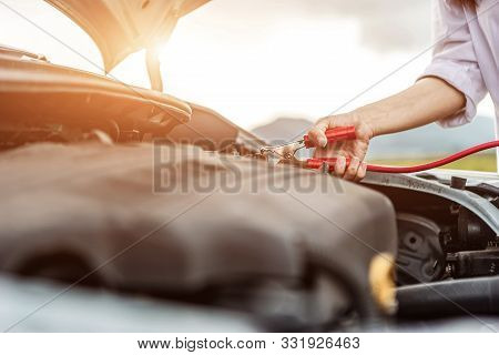 Asian Woman Uses Battery Jumper Cables For Chargers And Jump Starters A Dead Battery, Car Problem Or