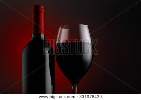 Bottle Of Red Wine With A Glass On A Black Background, Horizontal Close-up Image