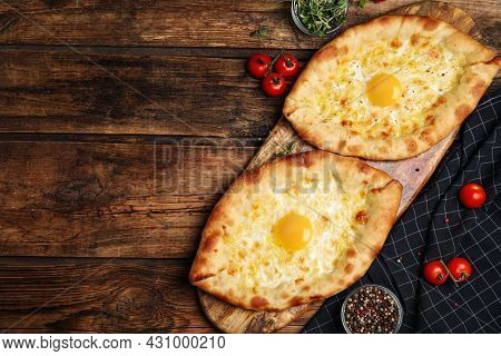 Fresh Delicious Adjarian Khachapuris Served On Wooden Table, Flat Lay. Space For Text