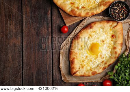 Fresh Delicious Adjarian Khachapuris Served On Wooden Table, Flat Lay. Space For Text
