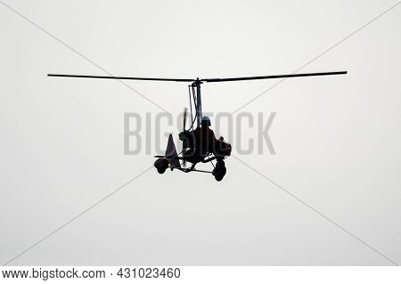 Flying Autogyro Silhouette On White Background.