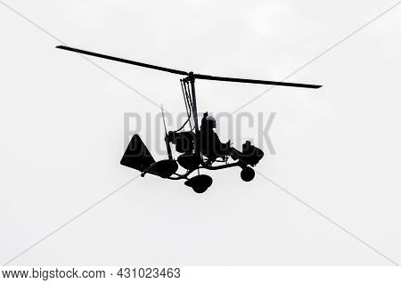 Flying Autogyro Silhouette On White Background.