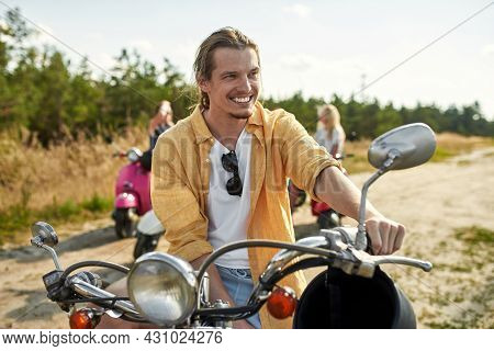 Happy Young Caucasian Boy Resting On Retro Scooter Outdoors In Warm Sunny Day With Company Of Friend