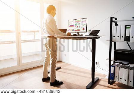 Height Adjusting Stand Desk In Office. Good Posture
