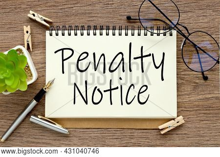 Penalty Notice, Notepad With Text On A Wooden Table. Notepad Near A Potted Plant