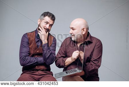 Old And Young. Old Father Together With Grown-up Son Look At Pc Screen. Generations And Modern Tech 