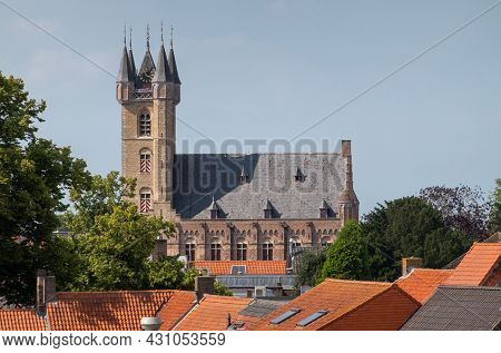 Sluis, The Netherlands - August 5, 2021: The Belfry Towering Over Town Houses With Red Roofs Under B