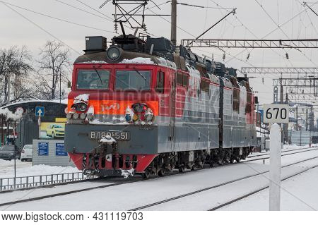 Close-up Of Electric Locomotive Vl80 In Winter On The Railroad. A Gray Winter Cityscape. Krasnodar, 