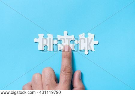 Hand Push A Piece Of Jigsaw Puzzle To Complete The Mission For Business Merging Concept Or Coorperat