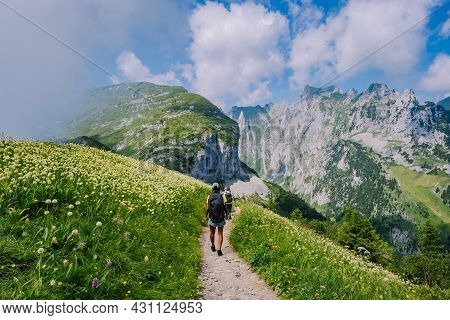A Woman With A Backpack Stands On Top Of A Mountain, The Girl Travels To Beautiful Places, Reaching 