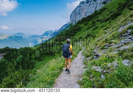 A Woman With A Backpack Stands On Top Of A Mountain, The Girl Travels To Beautiful Places, Reaching 