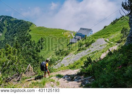 A Woman With A Backpack Stands On Top Of A Mountain, The Girl Travels To Beautiful Places, Reaching 