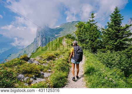 A Woman With A Backpack Stands On Top Of A Mountain, The Girl Travels To Beautiful Places, Reaching 
