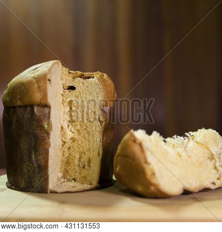 Panettone Slice On The Table. Panettone Cut On Wooden Table And Textured Background. Panettone Conce
