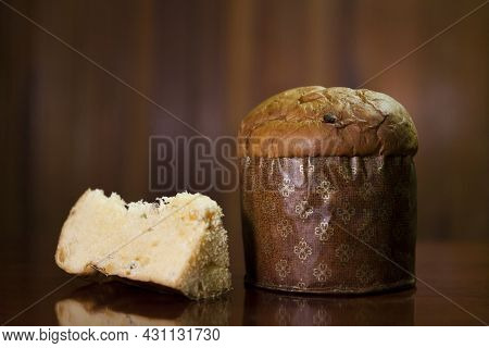 Panettone Slice On The Table. Panettone Cut On Wooden Table And Textured Background. Panettone Conce