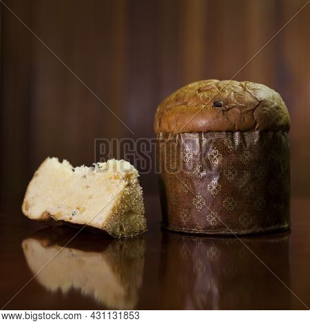 Panettone Slice On The Table. Panettone Cut On Wooden Table And Textured Background. Panettone Conce