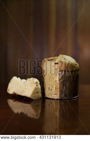 Panettone Slice On The Table. Panettone Cut On Wooden Table And Textured Background. Panettone Conce