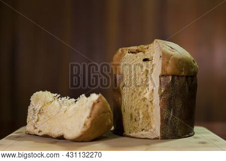 Panettone Slice On The Table. Panettone Cut On Wooden Table And Textured Background. Panettone Conce