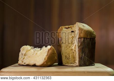 Panettone Slice On The Table. Panettone Cut On Wooden Table And Textured Background. Panettone Conce