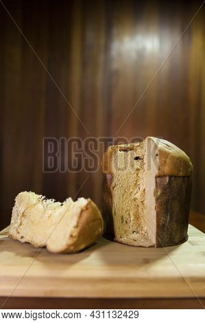 Panettone Slice On The Table. Panettone Cut On Wooden Table And Textured Background. Panettone Conce