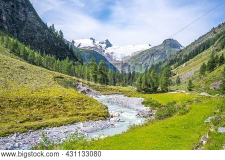 Idyllic Alpine Landscape With Grossvenediger Mountain. Small Mountain Creek In Gschloess Valley. Hoh