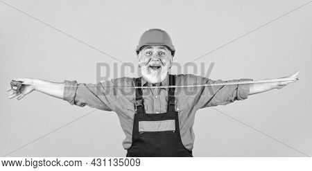 Confident Mechanic. Happy Carpenter. Handyman Measuring Wall. Senior Builder Tape-line For Measure. 