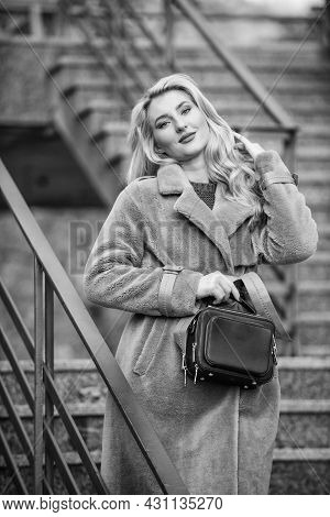Feeling Warm And Protected. European Winter. Girl Warm Coat Stairs Background. Faux Fur Coat Fashion