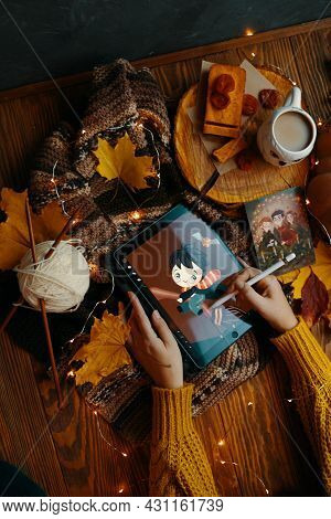 Young Woman In A Sweater Draws On A Tablet. Harry Potter Is Playing Quidditch On A Broomstick. Scarf