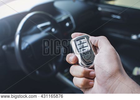 Car Keyless Entry Remote In A Hand Of The Owner Car With Car Interior Blurred Background