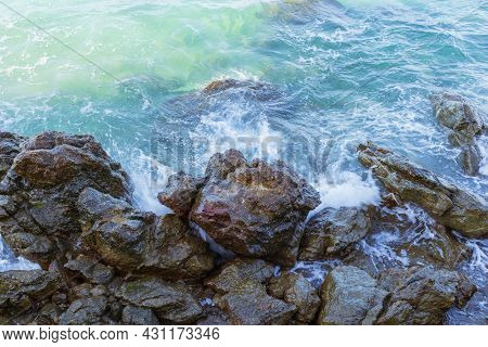 A View Of The Turquoise Sea With Waves Crashing Against The Many Rock Formations Can Be Used As A Ba