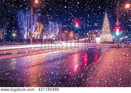 Night City With Christmas Decorations, Spruce And Traces Of Headlights Of Moving Cars, Reflected In
