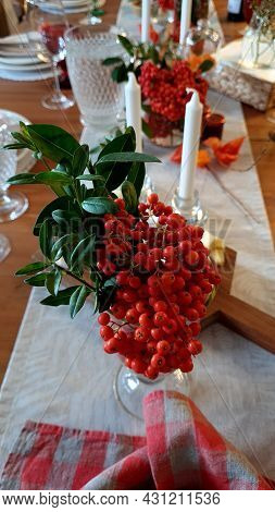 Decorative  Composition With Rowan Berries, Rose Hips  With A Candle On A White Table