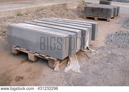 The Pallet With A Stack Of Concrete Curbstone. Stack Of Gray Curbstone On Pallet Standing On Pavemen