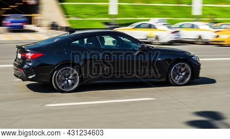 Black Bmw 420i G22 Coupe On The Road In Motion. Fast Speed Drive On City Road. Side View Of Moving B