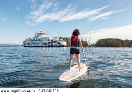Victoria, Vancouver Island, British Columbia, Canada - August 15, 2021: Adventurous Woman Paddle Boa