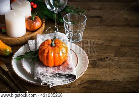 Autumn Table Setting With Plate, Pumpkin And Candles.